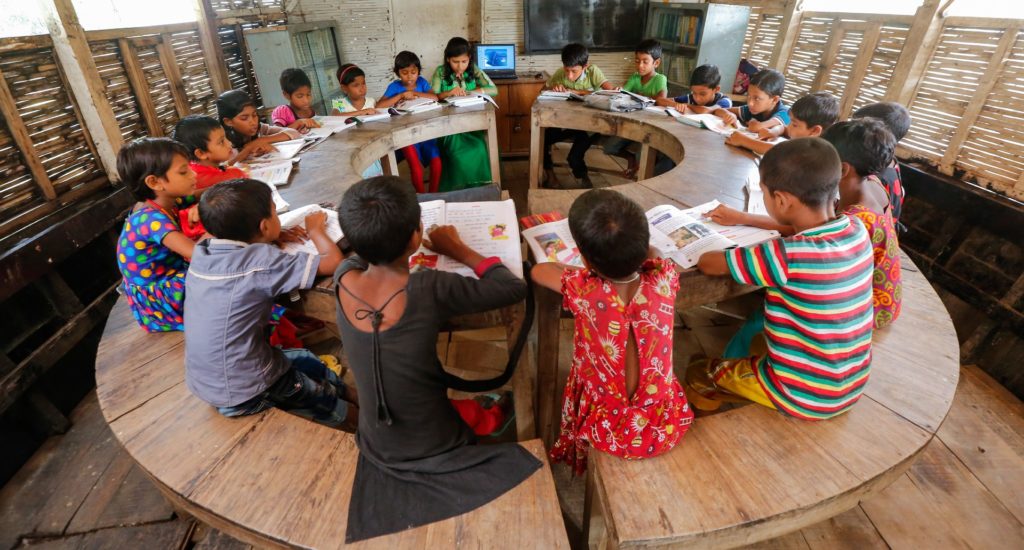 Children sitting at a round table in a school classroom