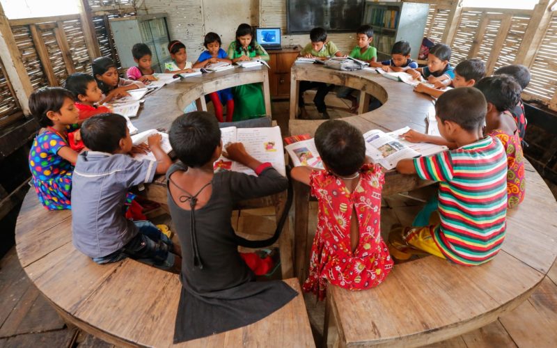 Children sitting at a round table in a school classroom