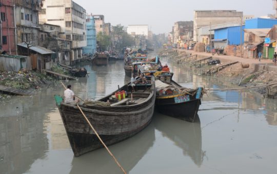 Large boats on a low river in a city