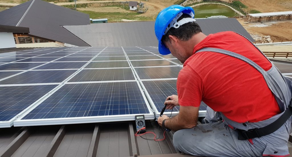 A technician installing solar panels on a roof