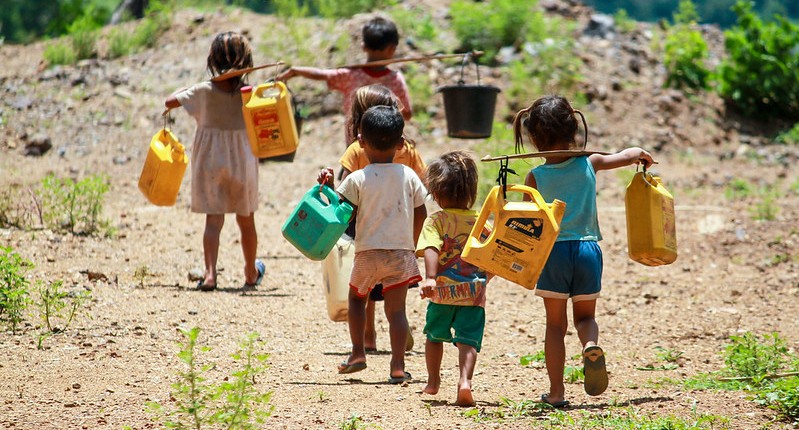 Children carrying water containers