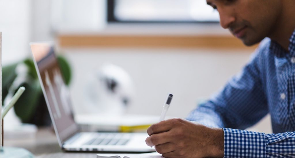 A man writing on a notepad