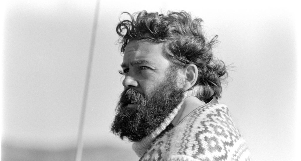 A black and white photo of a man with dark hair and beard