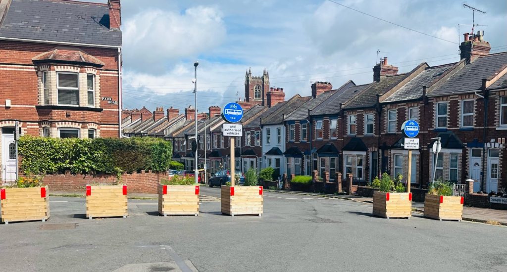 A residential road with large planters placed to block car access