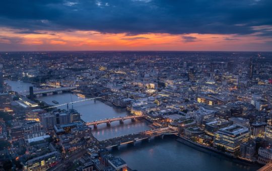 A view of London at sunset, with a large portion of the city's rooftops visible