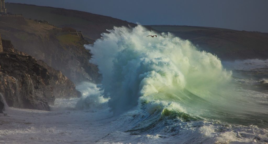 A large wave crashing on a beach