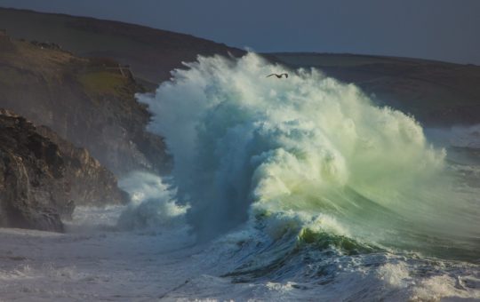 A large wave crashing on a beach