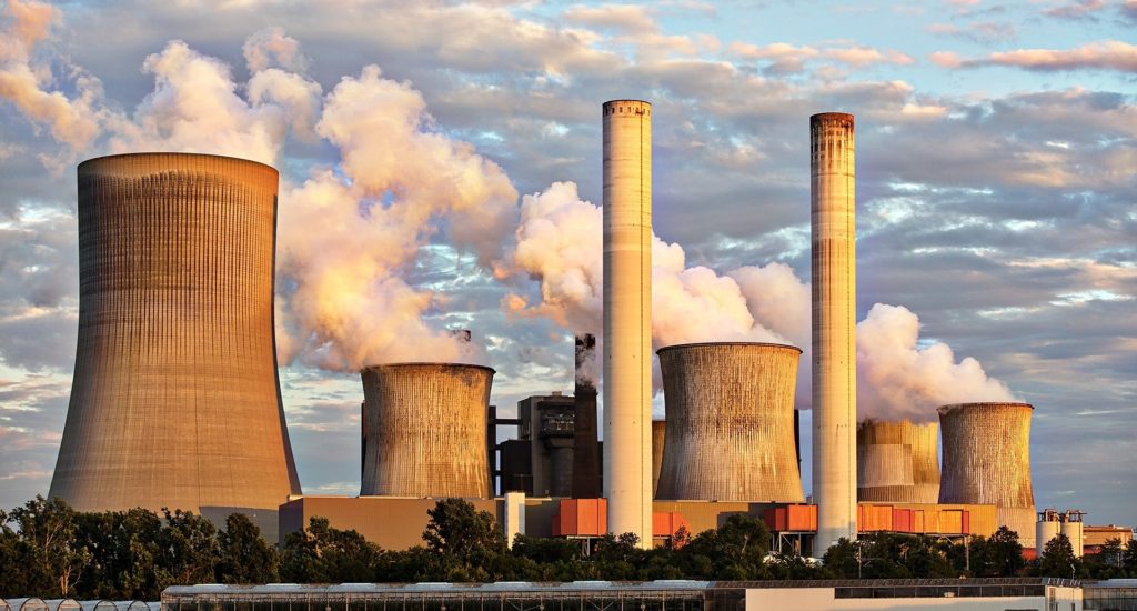 A coal power station, with smoke/steam coming from the chimneys & towers