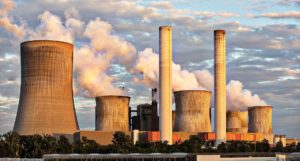 A coal power station, with smoke/steam coming from the chimneys & towers