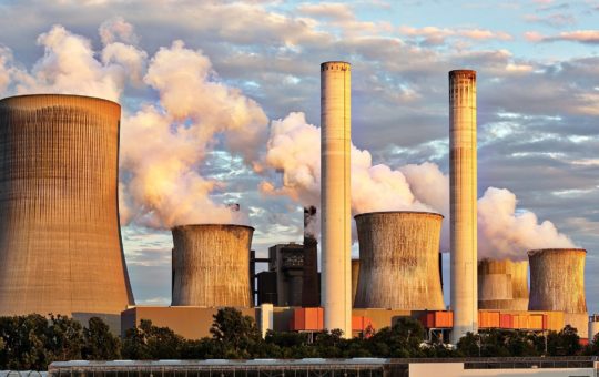 A coal power station, with smoke/steam coming from the chimneys & towers