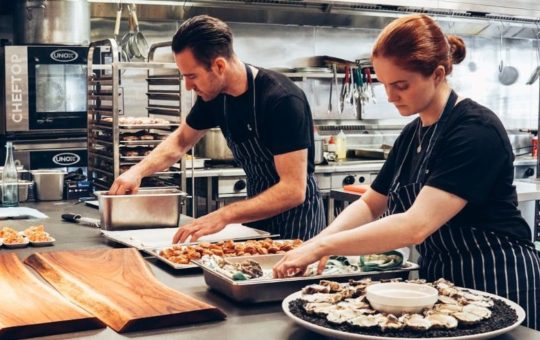 Man and Woman Wearing Black and White Striped Aprons Cooking