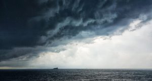 A ship at sea, with storm clouds overhead