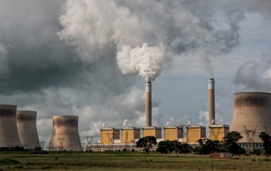 A power station, with chimneys releasing smoke