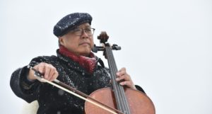 Yo-Yo Ma playing a cello outside in snowy conditions