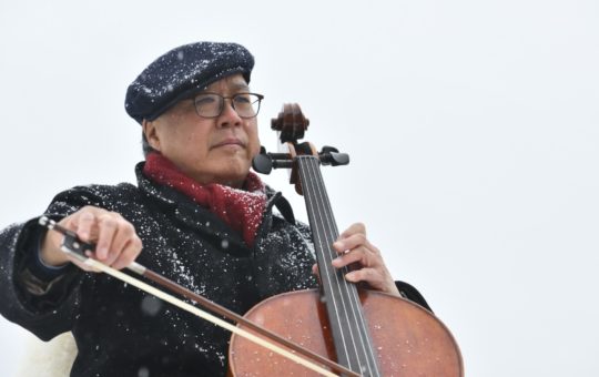 Yo-Yo Ma playing a cello outside in snowy conditions