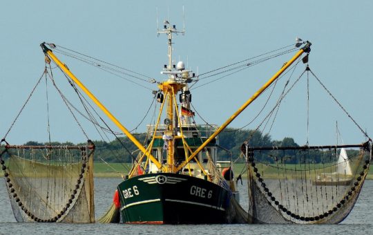 A trawler with nets hanging either side