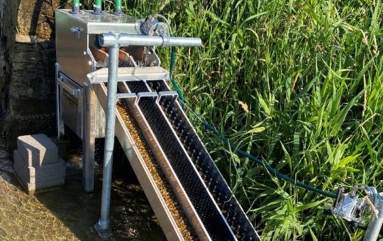 An eel pass - a sloping metal structure with three channels and pipes