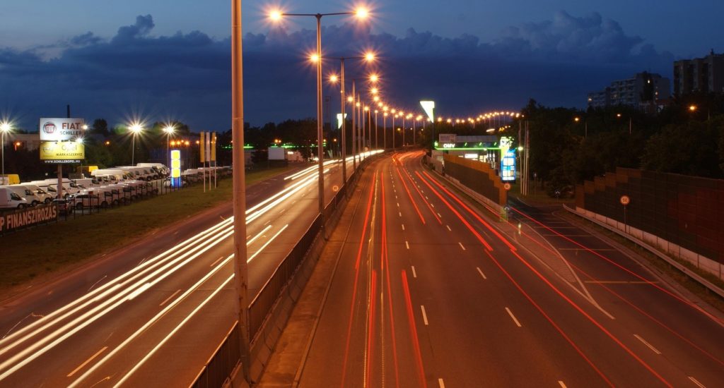An image showing a motorway at night, with vehicle lights blurred into streams.