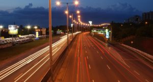 An image showing a motorway at night, with vehicle lights blurred into streams.
