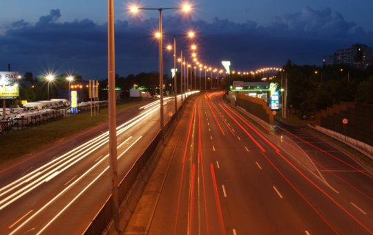 An image showing a motorway at night, with vehicle lights blurred into streams.