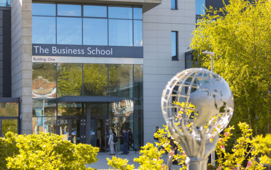 An external photo of the entrance to Building:One, the Business School, at the University of Exeter.