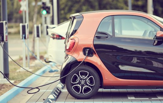 A line of electric cars attached to chargers