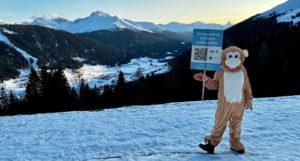 A person dressed in a monkey costume holding up a placard that says "giving nature a voice in policy"