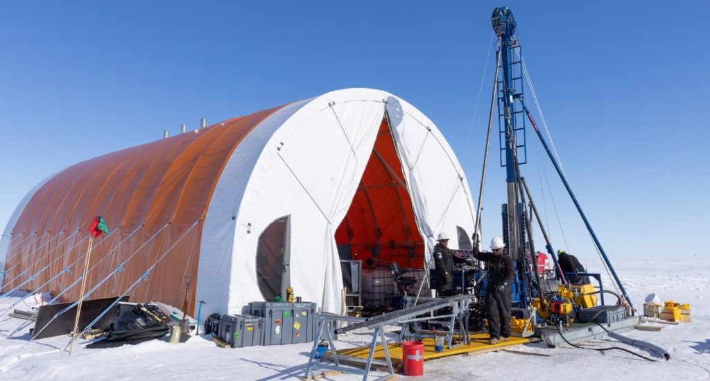A large drill set up outside a tent on ice in Antarctica