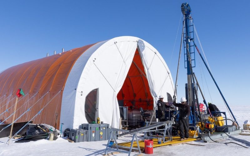 A large drill set up outside a tent on ice in Antarctica