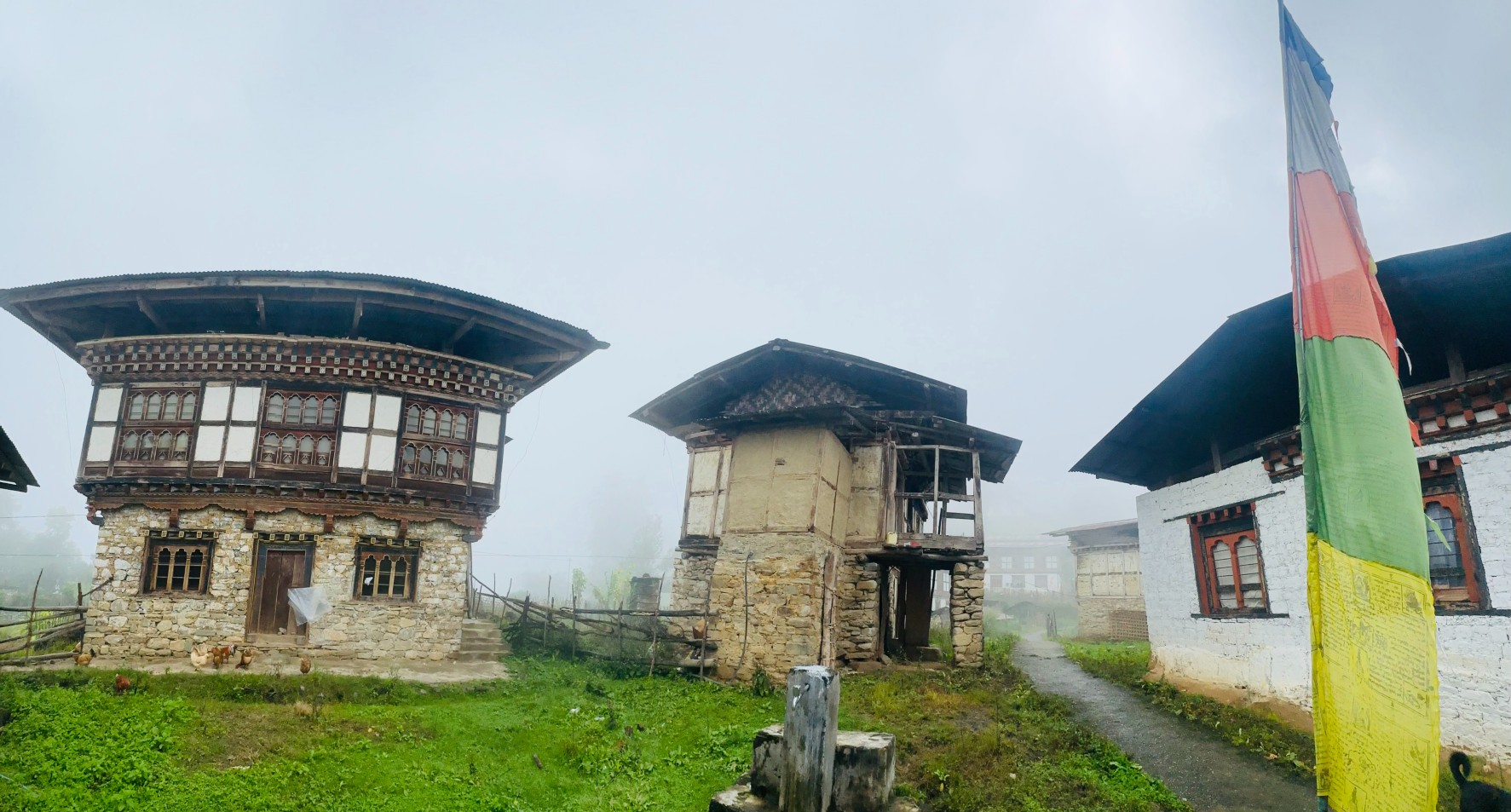 Three empty houses on a misty hill