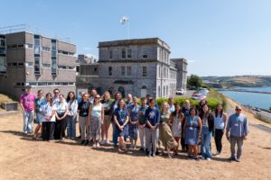 A group of people lined up in sunshine for a photo outside the MBA in Plymouth