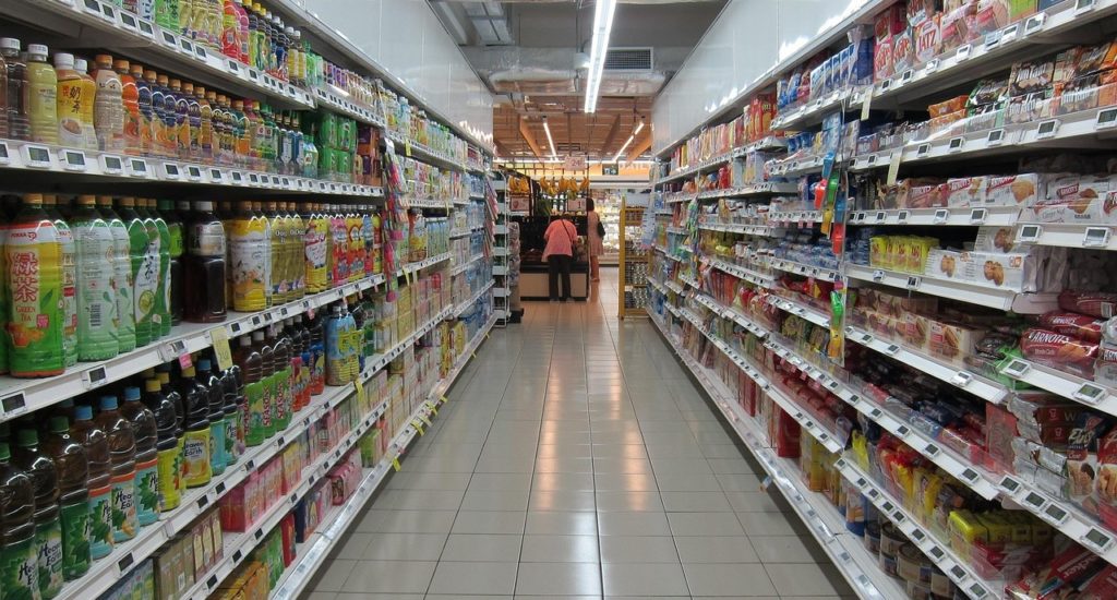 A supermarket aisle with a person visible at the far end