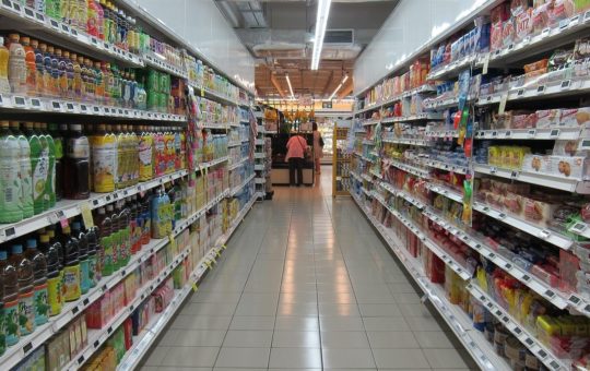 A supermarket aisle with a person visible at the far end