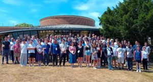 A Large group of people lined up for a photo on the grass outside the Peter Chalk Centre at the University of Exeter